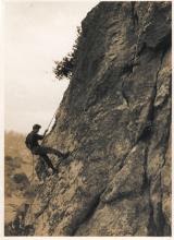 A roped climber on a steep rock face
